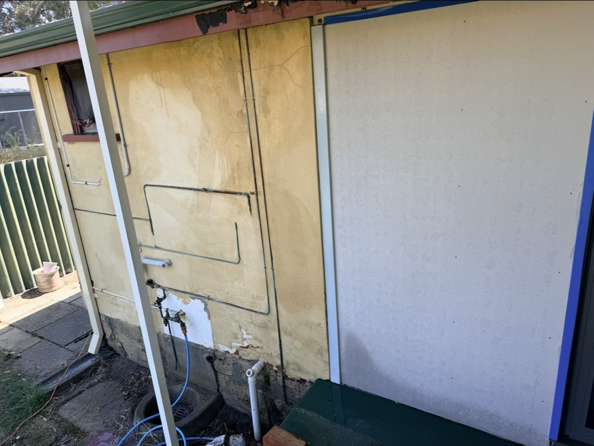 Closer view of the ageing and marked exterior render before restoration at the Victoria Park home